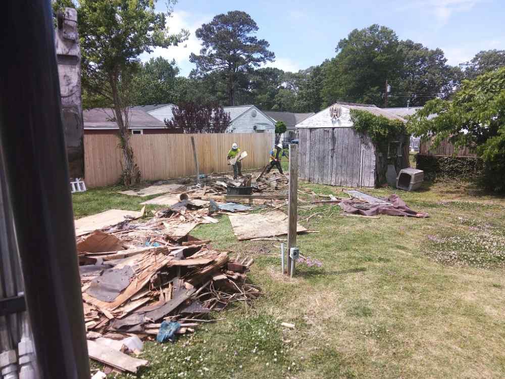 Demolition crew clearing wooden debris during a residential shed removal and site clearing project.