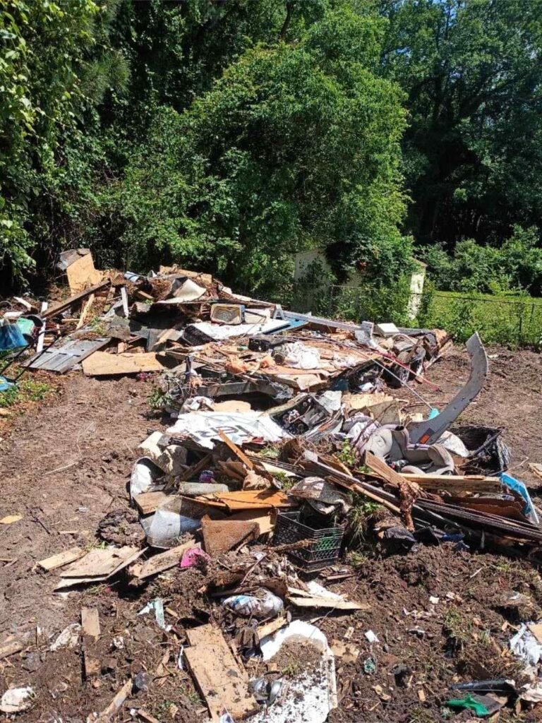 Debris pile and structural remnants from a residential demolition and site clearing project.