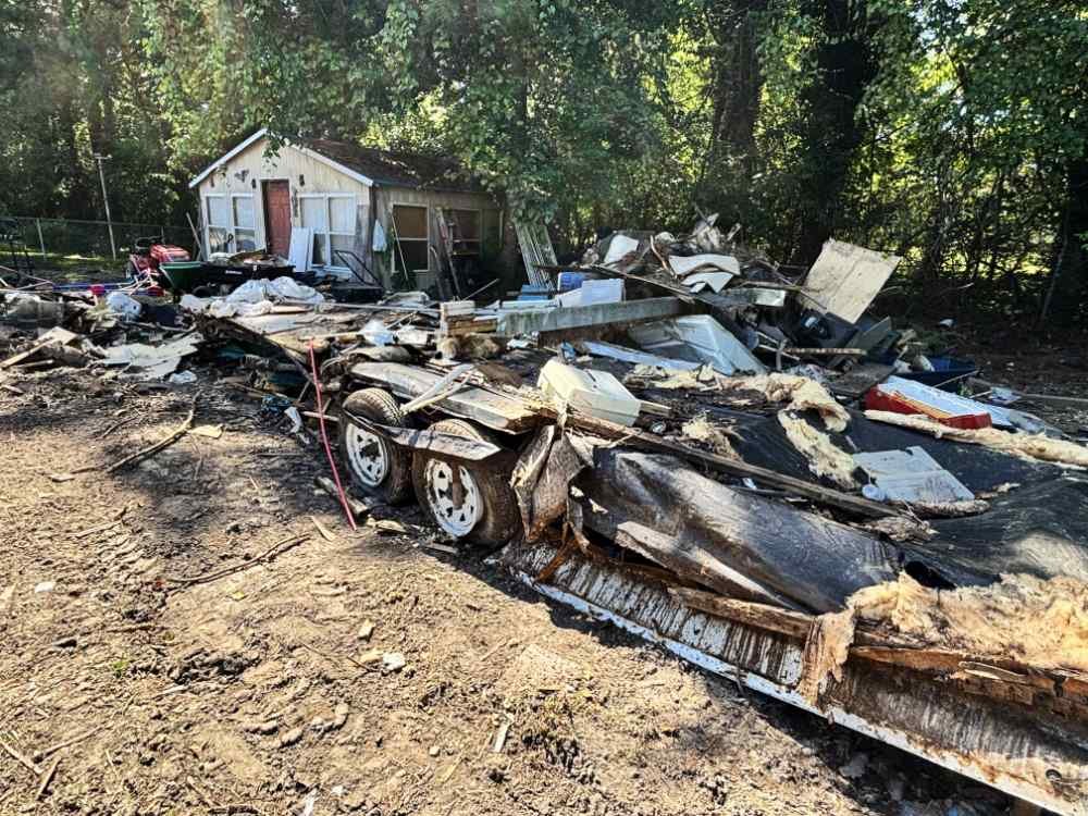 Mobile home teardown and debris pile during residential demolition and site clearing.