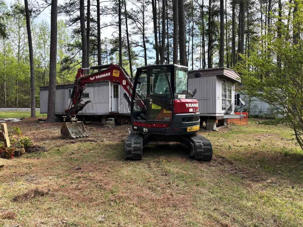 Yanmar excavator parked at a mobile home teardown and site clearing project.