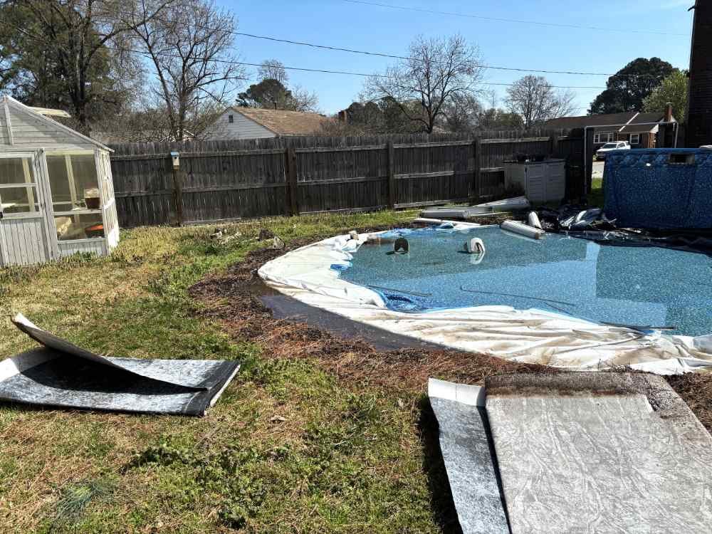 Residential backyard during an above-ground swimming pool removal and site demolition project.