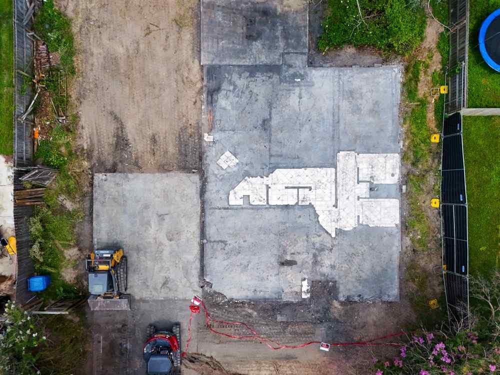 Aerial view of a concrete slab foundation remaining after demolition, ready for site clearing.