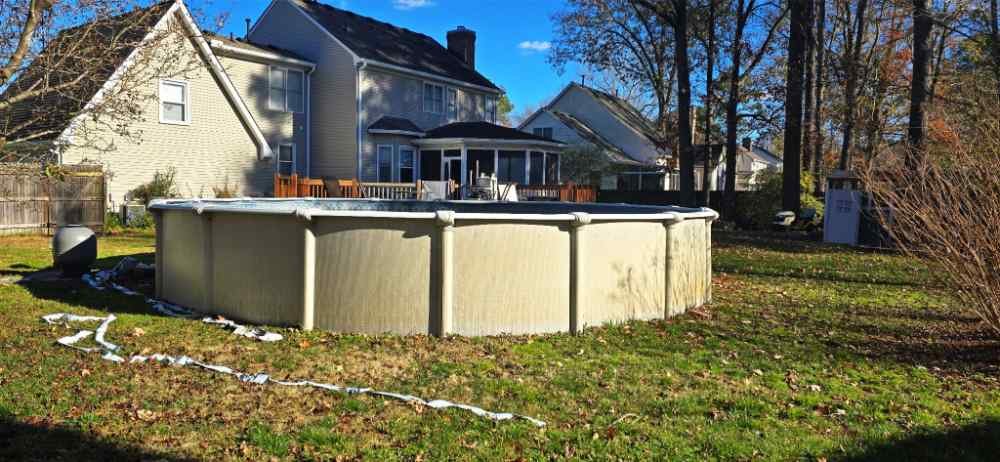 Above-ground swimming pool in a residential backyard scheduled for removal and demolition services.