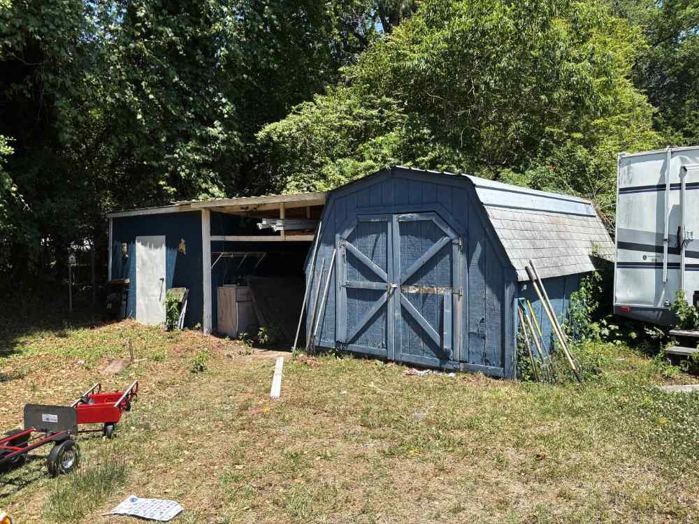 Weathered blue wooden shed and outbuilding ready for residential shed removal and site demolition services.