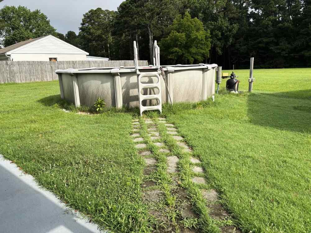 Residential above ground swimming pool in a backyard ready for removal and demolition services.