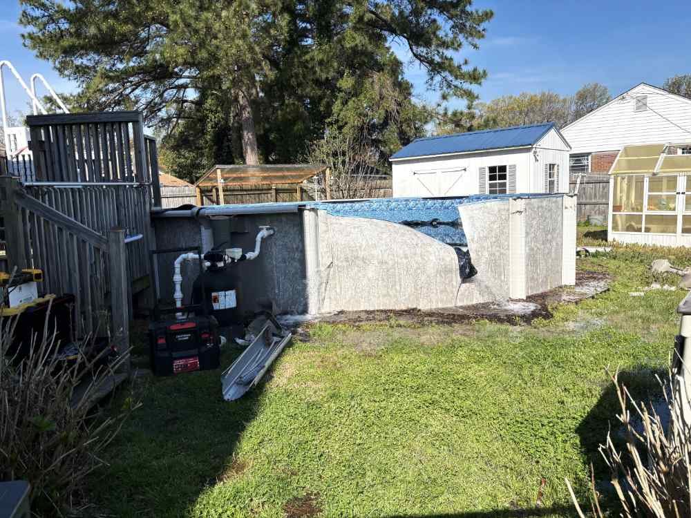 Partially dismantled above-ground pool during a residential pool demolition and removal project.