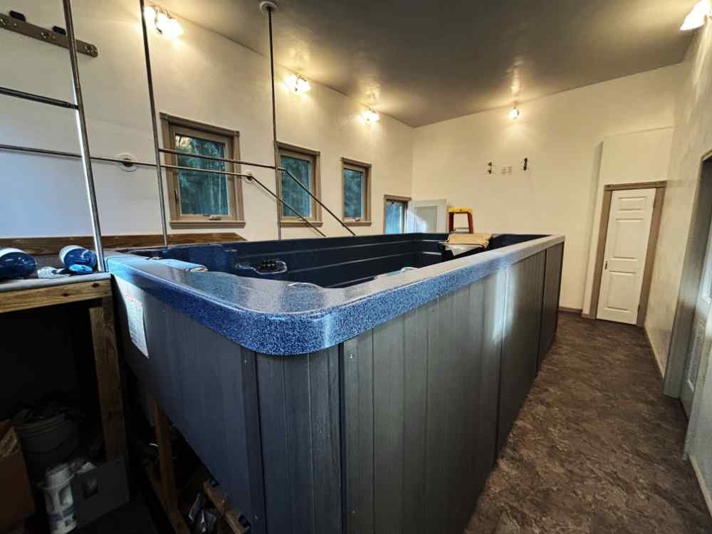 Indoor hot tub removal and residential demolition preparation in a finished room.