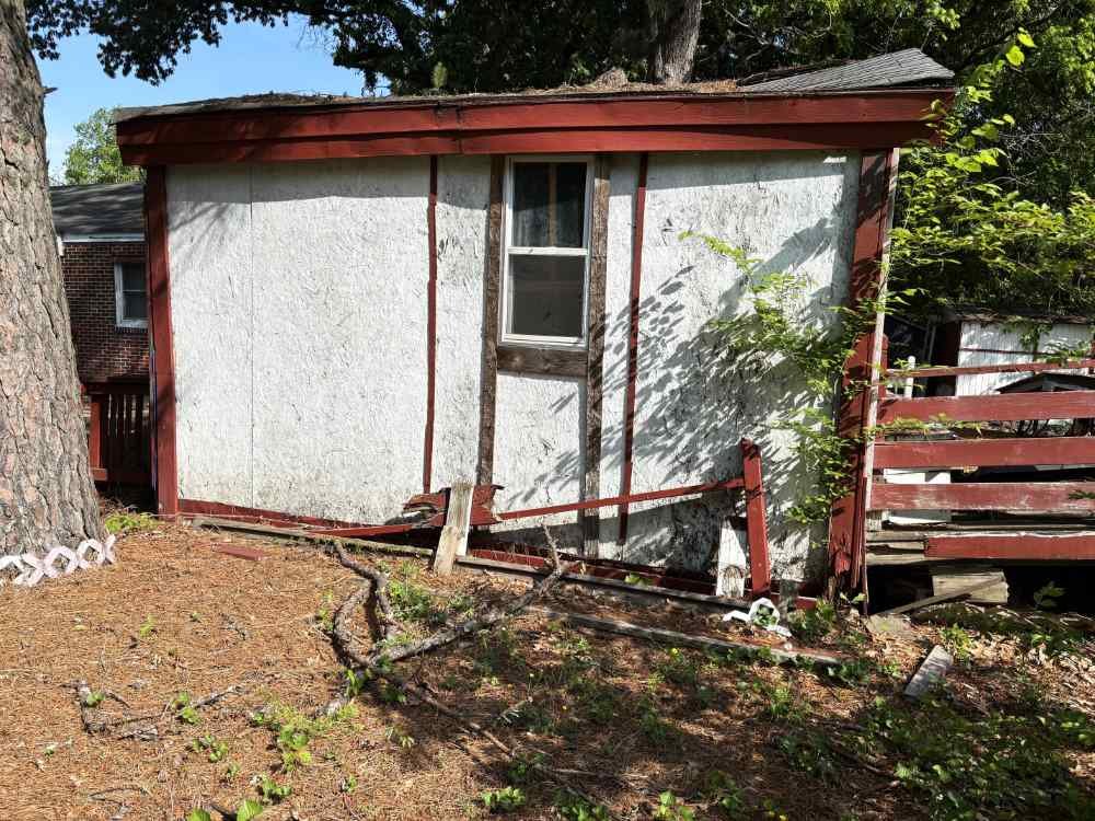 Old wooden shed slated for residential demolition and yard teardown service.