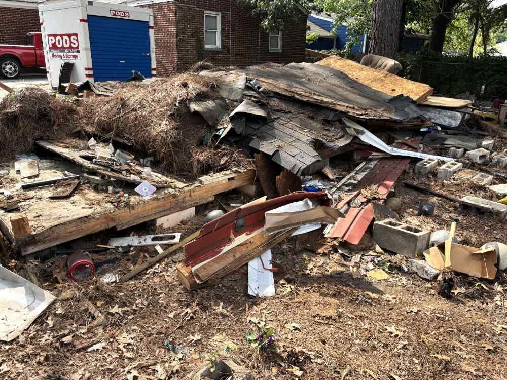 Large pile of residential demolition debris and building materials on a clearing site.